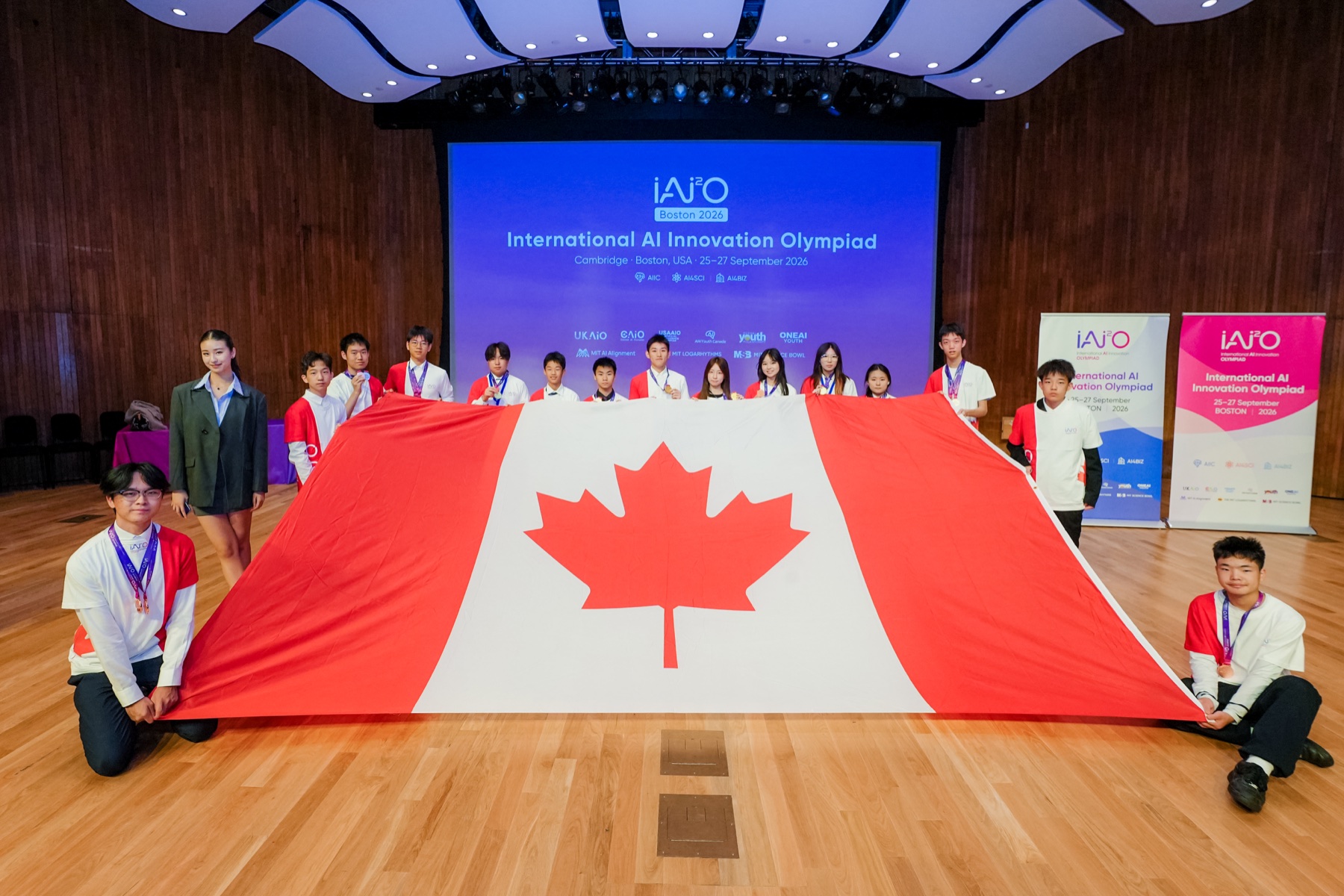Canadian participants holding a large Canadian flag at the 2026 IAI2O Global Final